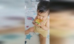 小孩吃瓜看着桃子,童趣盎然